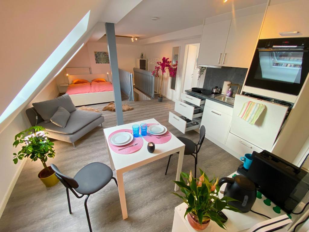 pequeña sala de estar con mesa y cocina en Ruhige, Neue Dachwohnung an Altstadt, Nahe Messe, en St. Gallen