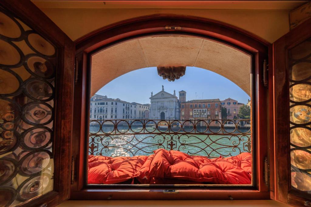 een glazen raam met uitzicht op de stad bij Ca' Emo Palazzo sul Canal Grande in Venetië