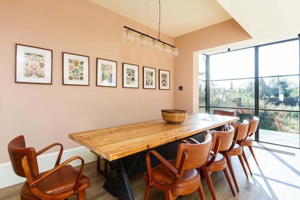 a dining room with a wooden table and chairs at Lewknor Lodge: Stunning 5 bed, 4 bathroom house in Ramsgate in Kent