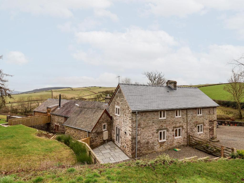 an old stone house in the middle of a field at Rockhill Farmhouse in Craven Arms
