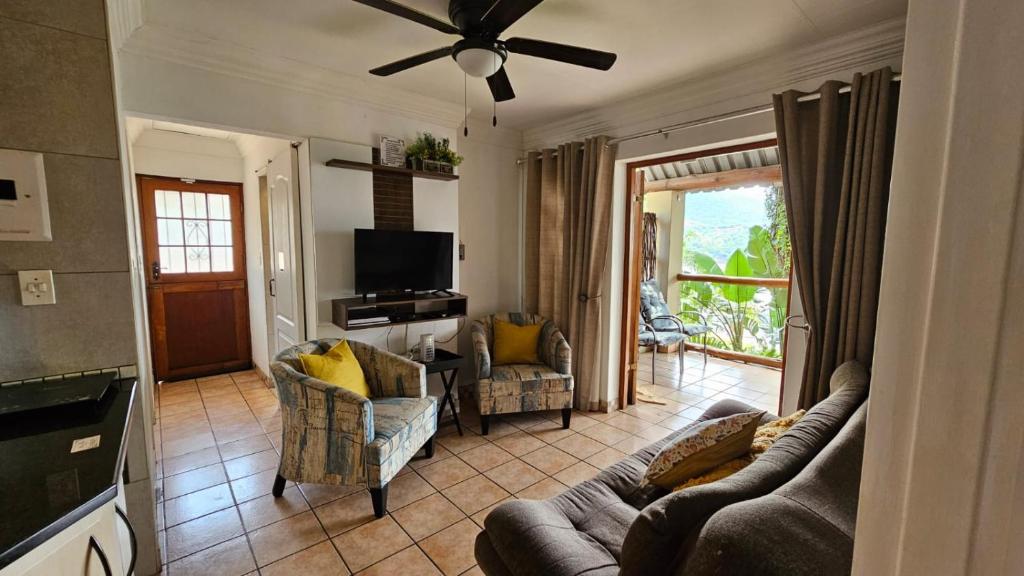 a living room with a couch and chairs and a television at Pont de Fleur in Hartbeespoort