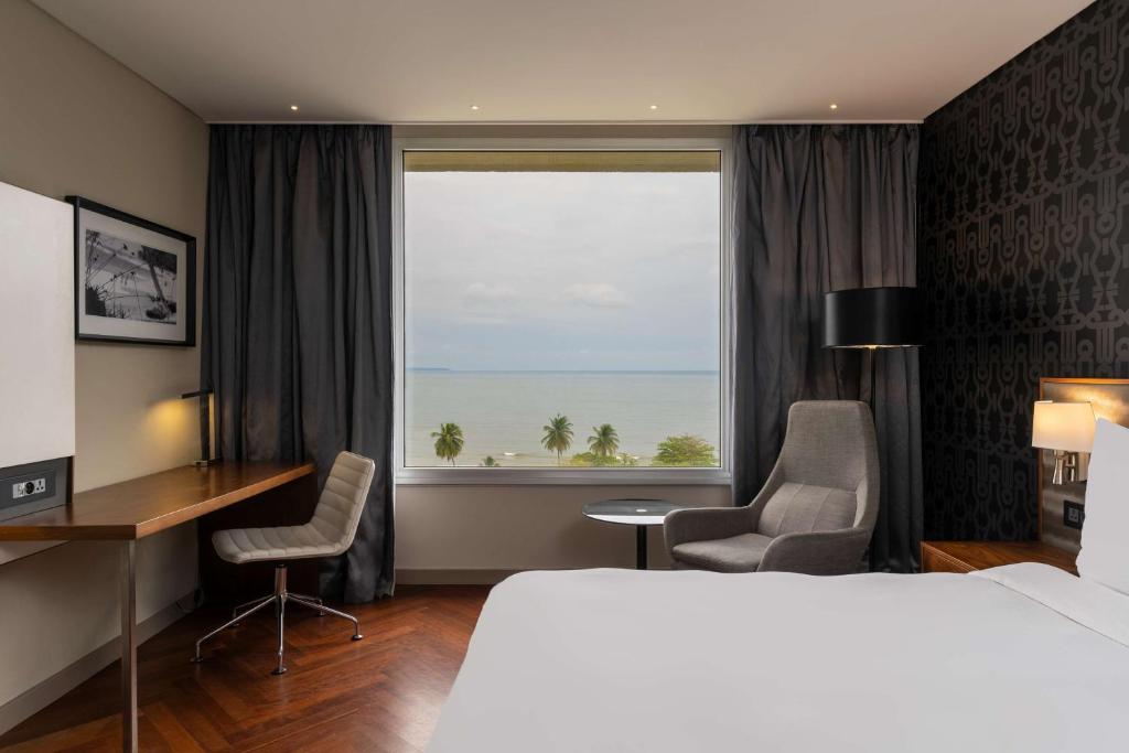 ein Hotelzimmer mit einem Bett, einem Schreibtisch und einem Fenster in der Unterkunft Radisson Blu Okoume Palace Hotel, Libreville in Libreville