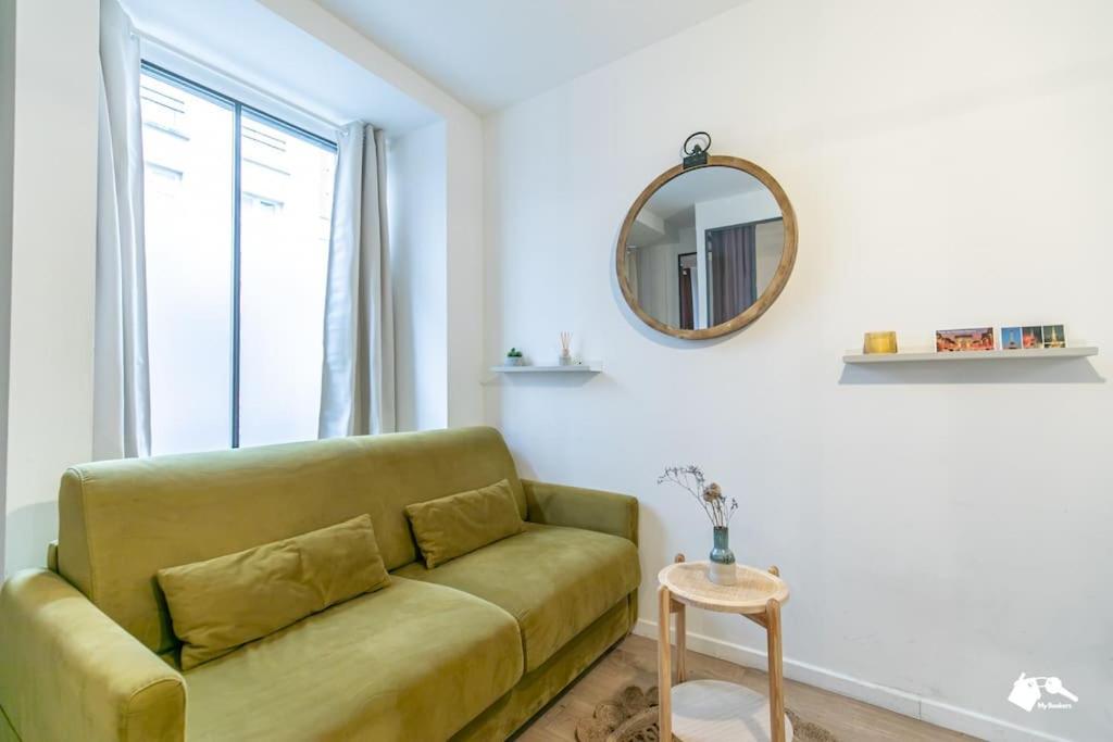 a living room with a couch and a mirror at MBA - Splendide Appart - Gambey 1 - Proche République in Paris