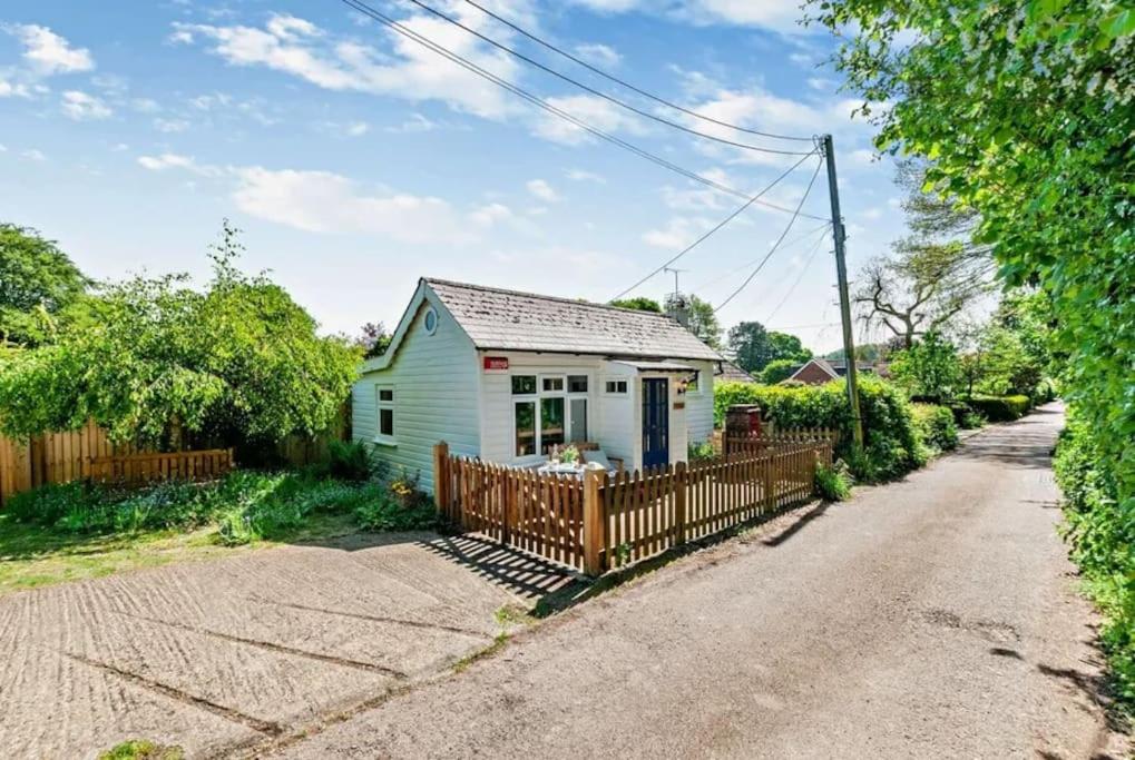 una pequeña casa blanca con una valla de madera en Cosy Cottage near Canterbury - Perfect for Couples - Dogs Welcome! en Canterbury