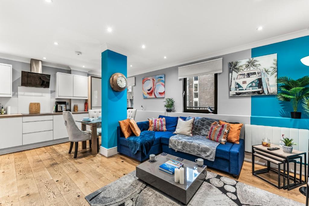een woonkamer met een blauwe bank en een keuken bij Grab the remainder of June - leisure, contractors in Bristol
