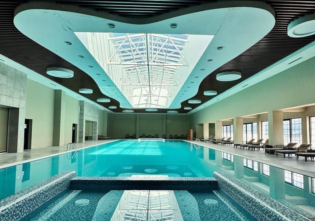 a large swimming pool in a building with a ceiling at Deluxe Park Qusar Resort & Spa Hotel in Qusar