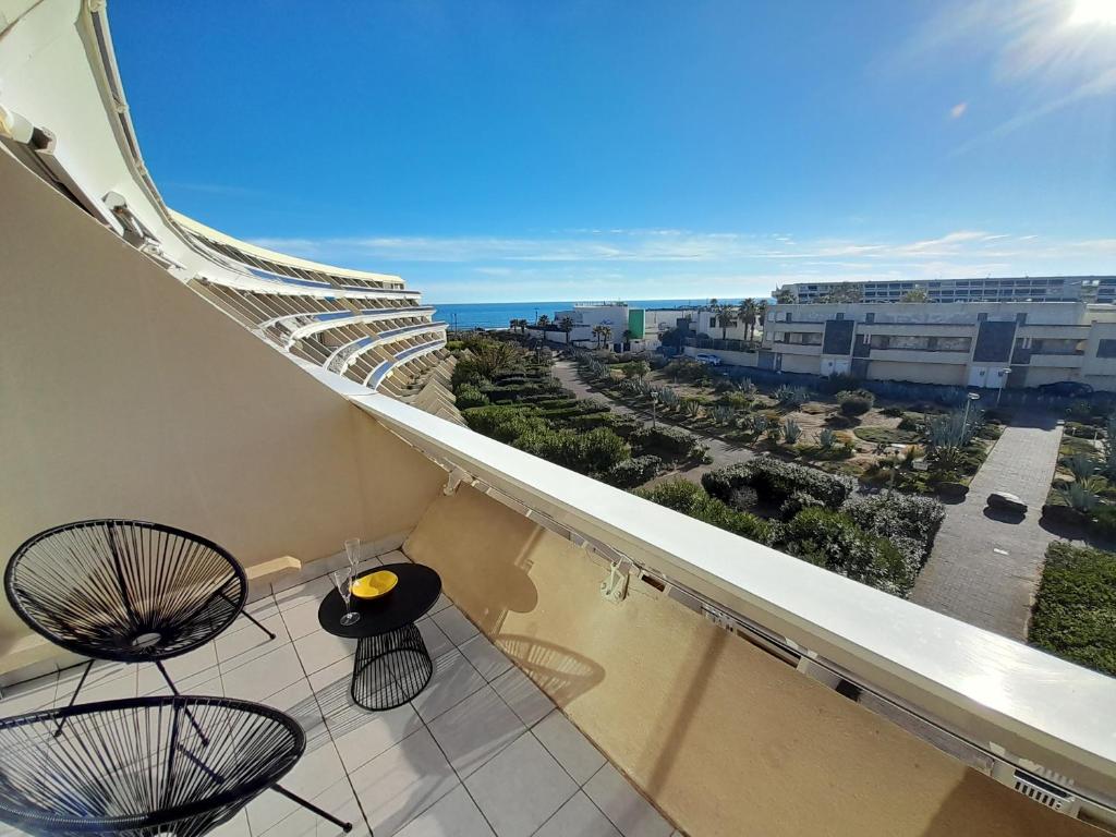 un balcon avec deux chaises et une vue sur l'océan dans l'établissement Studio Village Naturiste Farniente, au Cap d'Agde