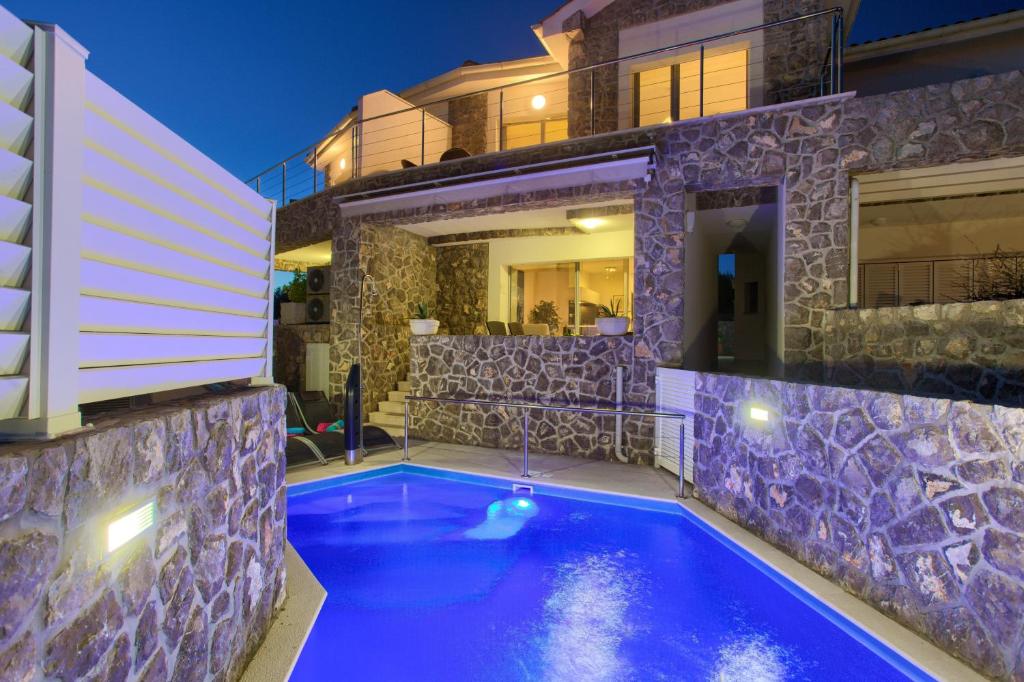 a swimming pool in front of a house at night at Villa Miracle 1 with heated pool in Krk