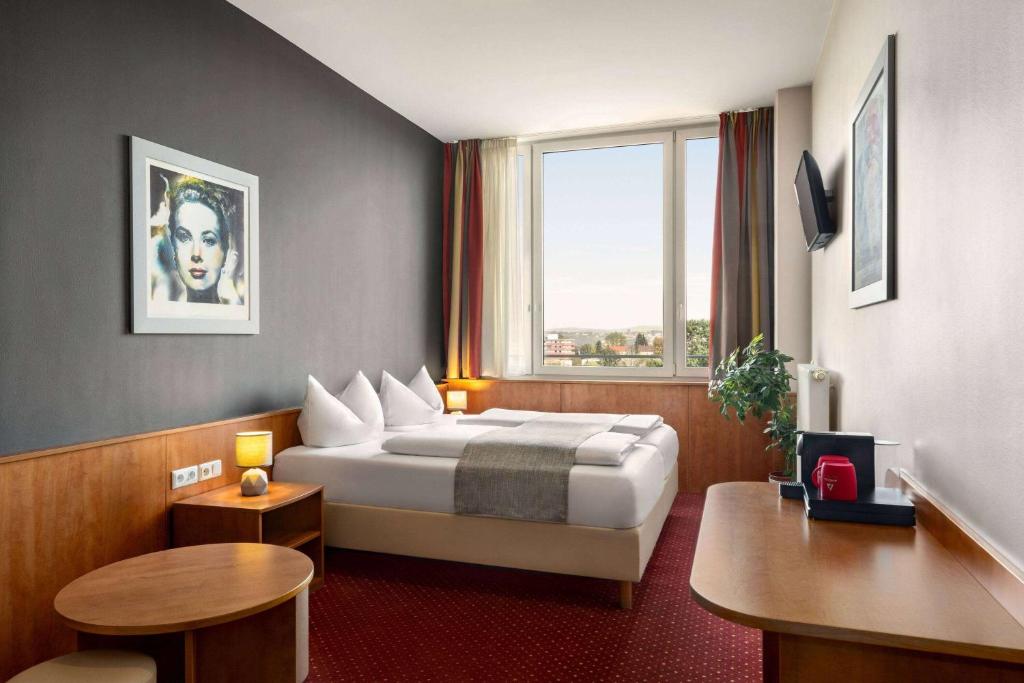 a hotel room with a bed and a window at Amedia Express Passau, Trademark Collection by Wyndham in Passau
