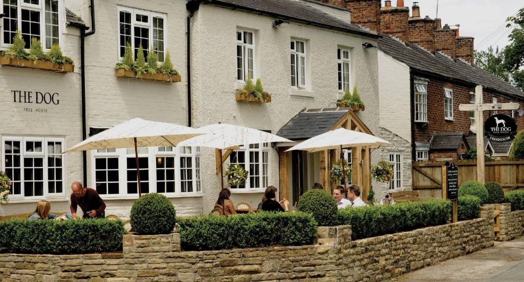 un grupo de personas sentadas fuera de un edificio en The Dog in Over Peover en Knutsford