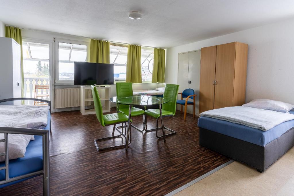 een slaapkamer met een bed en een tafel en stoelen bij Monteurapartment 7 in Rodgau