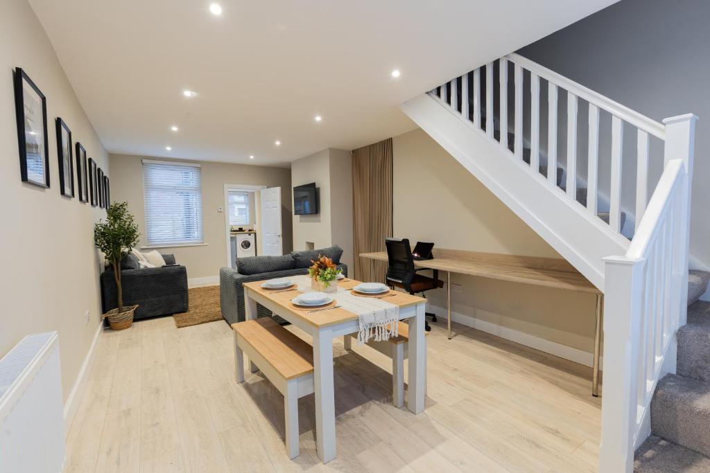 uma sala de estar com uma mesa e uma escada em Newly Renovated Family and Workspace Business Home in Runcorn, Cheshire ENTIRE HOUSE 