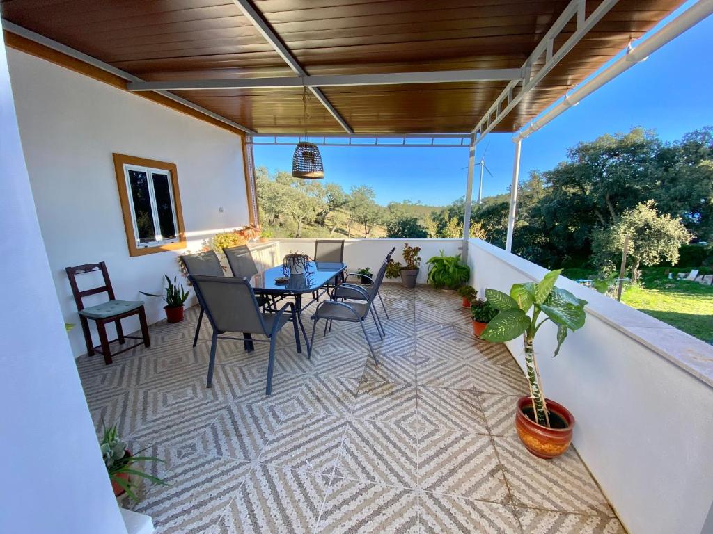 Un patio con una mesa y sillas en un balcón. en Casa Ti Barbara, en Cachopo