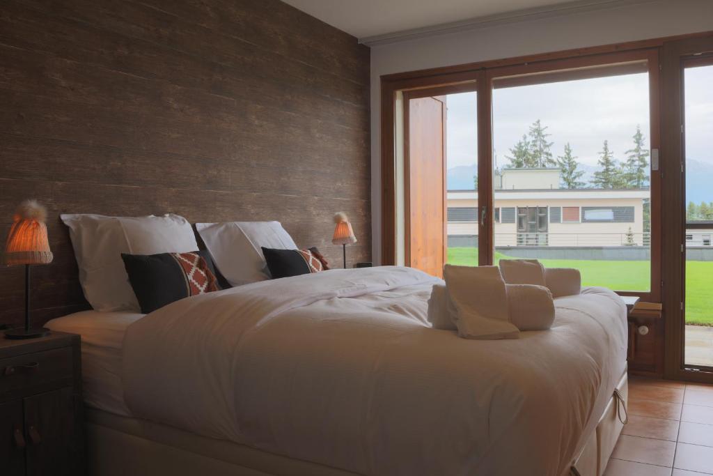 Schlafzimmer mit einem großen weißen Bett und einem großen Fenster in der Unterkunft Croisée A in Lens