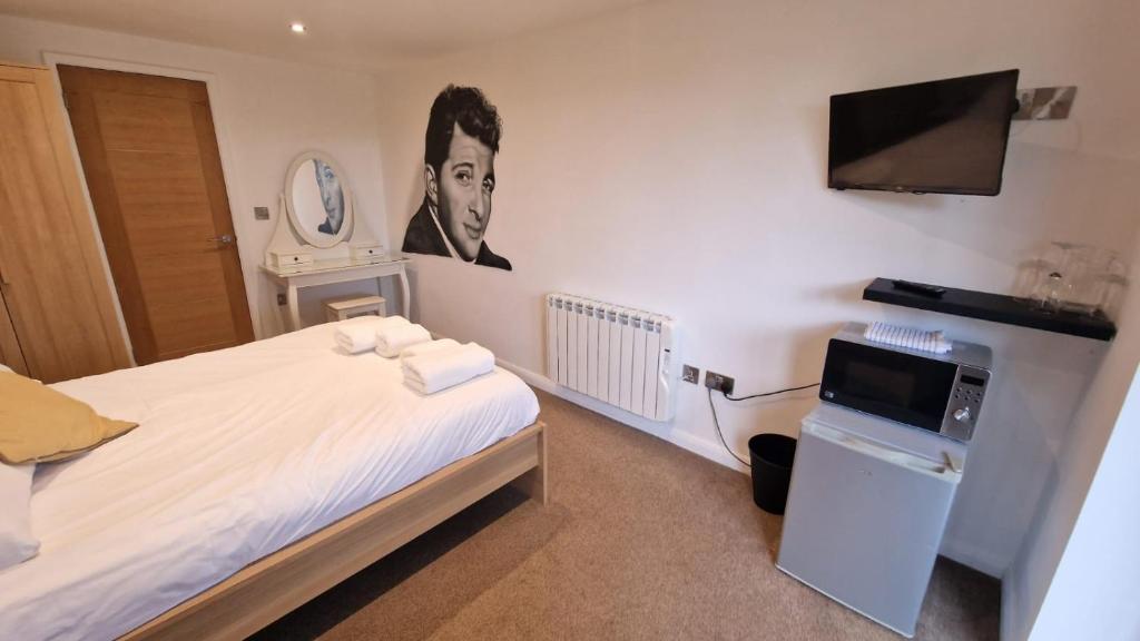 a hotel room with a bed and a television at Relaxing Room With Ensuite Rutland Point in Oakham
