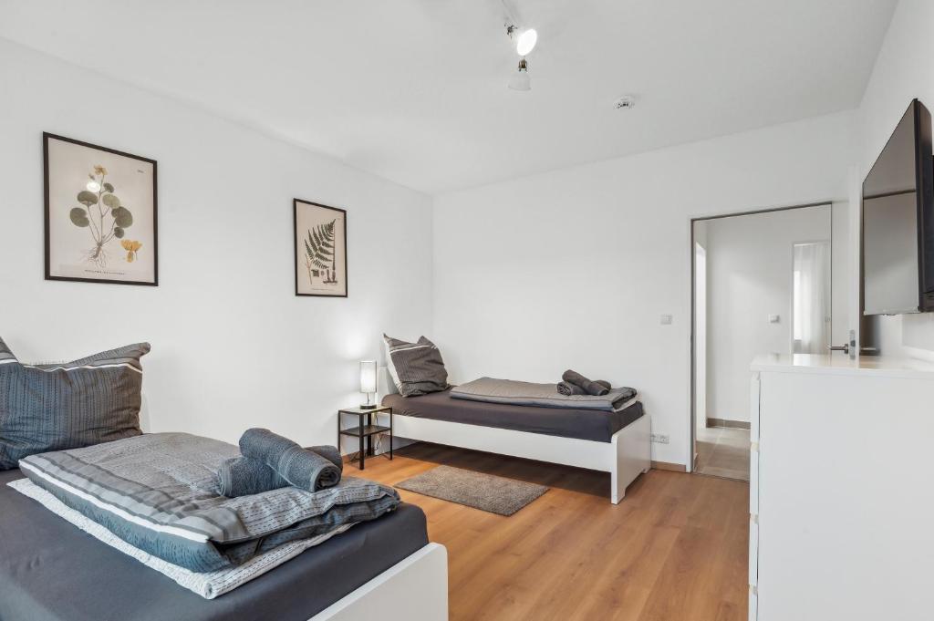 um quarto branco com uma cama e um sofá em SC01 Großes Apartment bei FFM! em Mörfelden-Walldorf