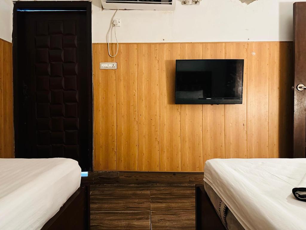 a room with two beds and a television on a wall at Hotel SeaView 2 in Karachi