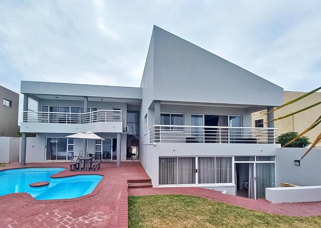 a large house with a swimming pool in front of it at Glen Ashley Beach Villas in Durban