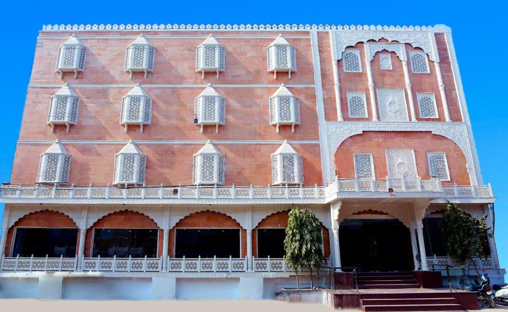 un gran edificio de ladrillo rojo con ventanas y escaleras en HOTEL PRAHLAD INN, en Gwalior