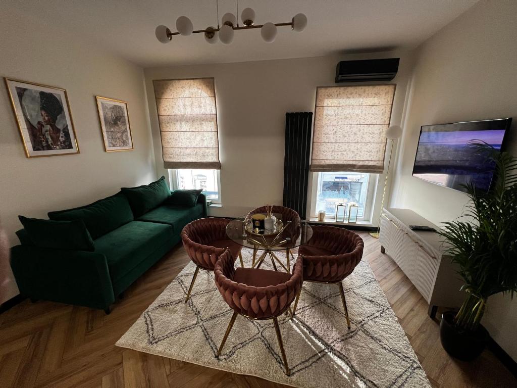 a living room with a green couch and a table at Apartament Starówka Bulvar 11 in Elblag