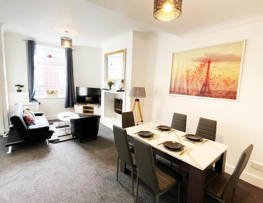 a living room with a dining room table with chairs at Failsworth, Manchester in Manchester