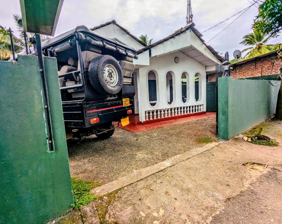 a truck parked in front of a small house at Udawalawa Safari House in Udawalawe