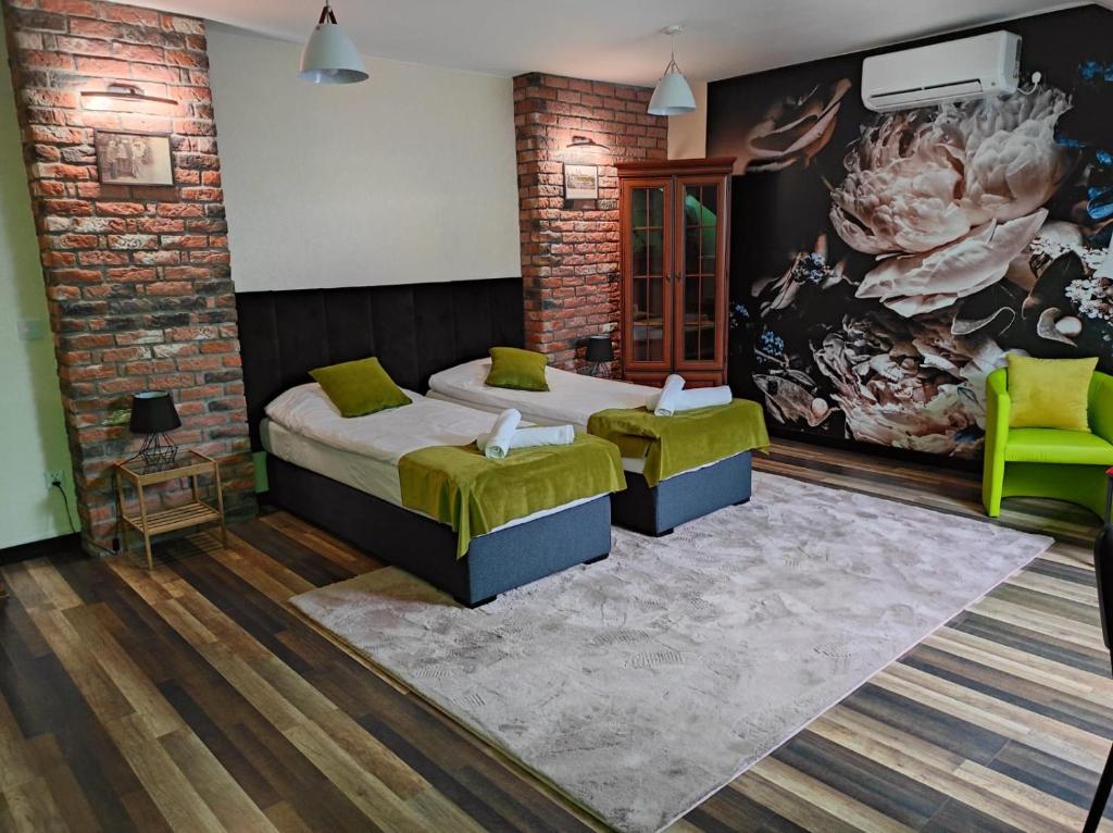 a bedroom with two beds and a brick wall at Harmonica PREMIUM in Nowy Sącz