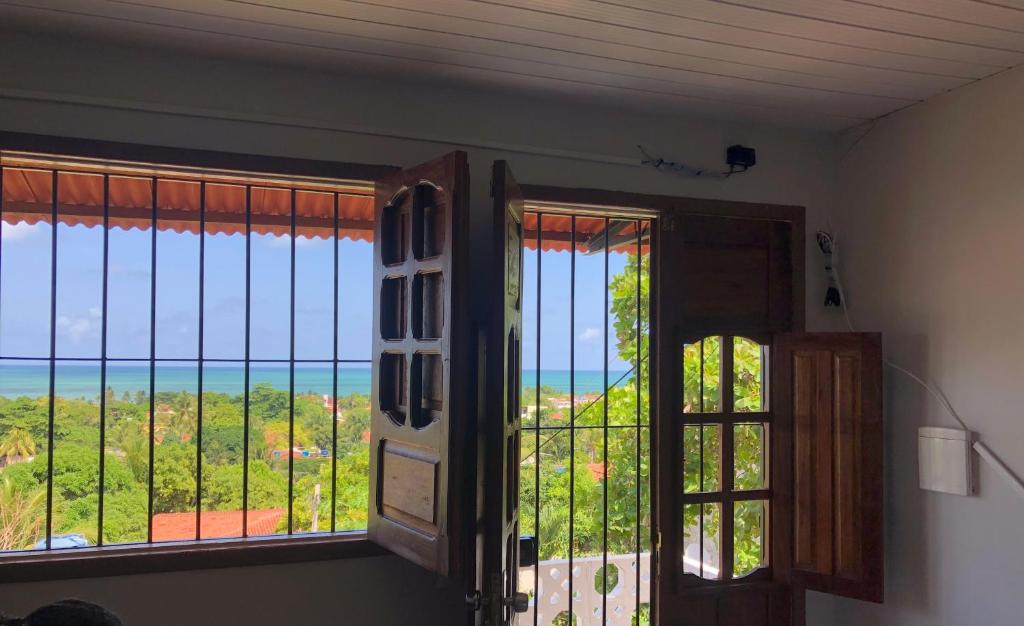 Cette chambre dispose d'une fenêtre offrant une vue sur l'océan. dans l'établissement Praia de Ponta de Pedras, vista privilegiada!, à Goiana