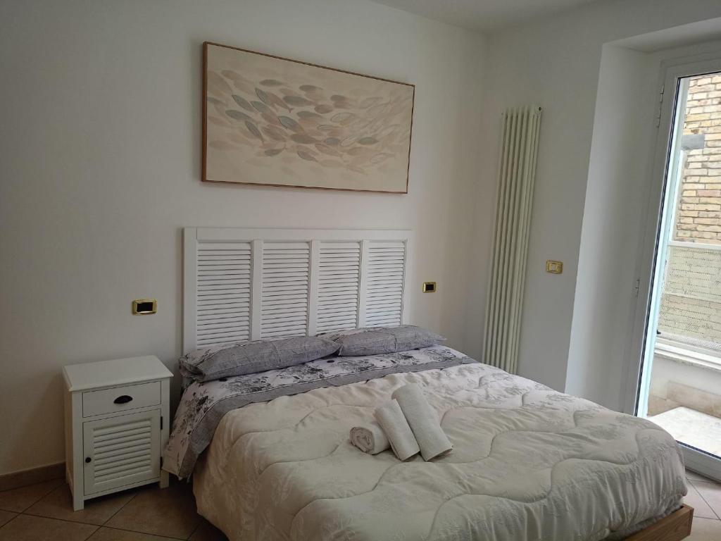 una camera da letto con un letto e due asciugamani di Da Enza - Appartamento al mare a Grottammare