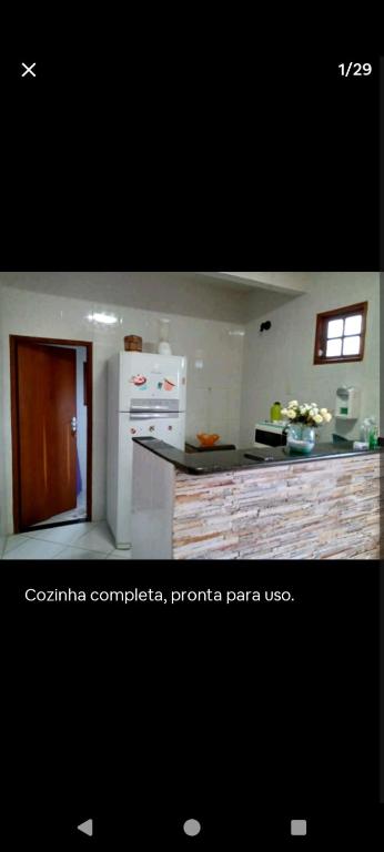 里約達斯奧斯特拉斯的住宿－Casa de Praia，厨房配有白色冰箱和台面