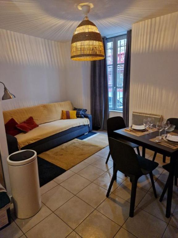 un salon avec une table et un canapé dans l'établissement Manel - Appartement T2 Rue st jean le vieux, à Avignon