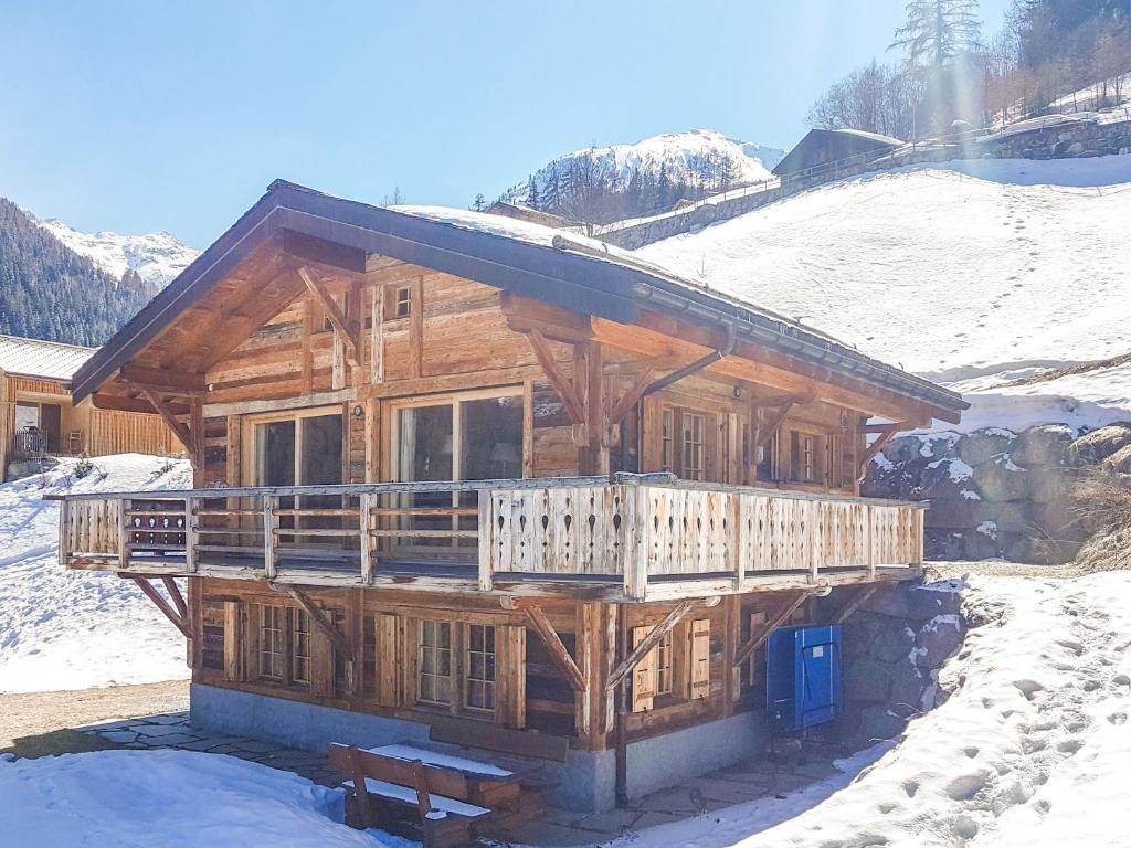 a large wooden cabin in the snow with a bench at Chalet Jessica in La Tzoumaz