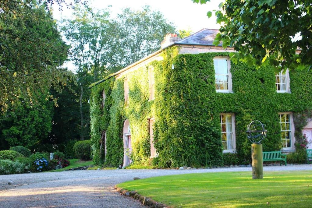 an ivy covered house with a street in front at Marlacoo House Luxury Georgian home in Portadown