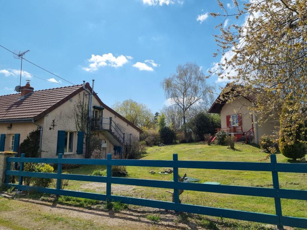 une maison avec une clôture bleue devant une cour dans l'établissement Domaine Le Beau Lavault, à Thil-sur-Arroux