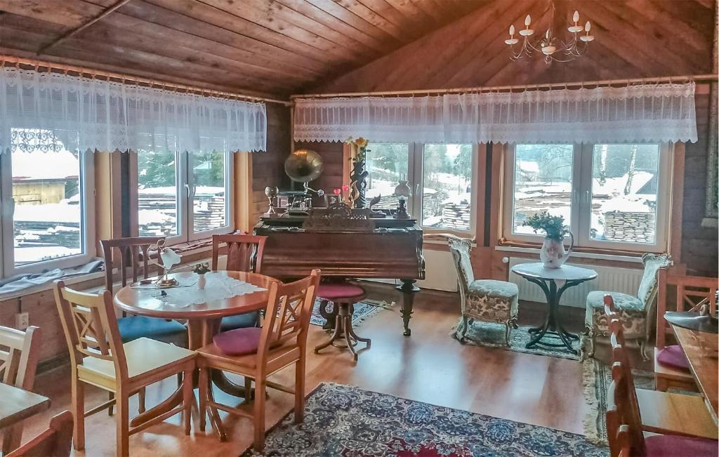 ein Esszimmer mit einem Tisch und einem Flügel in der Unterkunft 4 Bedroom Gorgeous Home In Kamianna in Kamianna