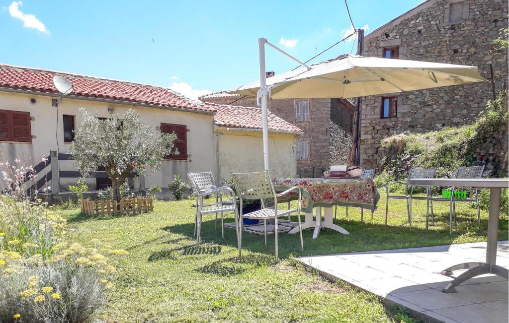 un patio con sombrilla, mesa y sillas en 3 Bedroom Stunning Home In Marignana, en Marignana