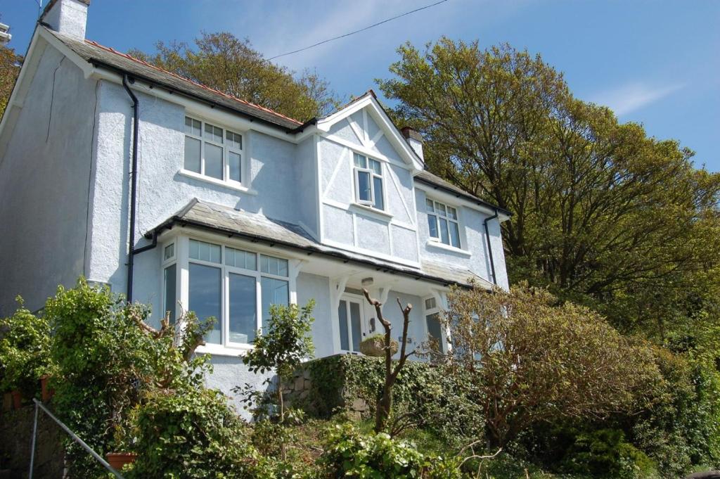 Casa blanca con ventanas blancas y árboles en Bryn Mair in Barmouth, en Barmouth