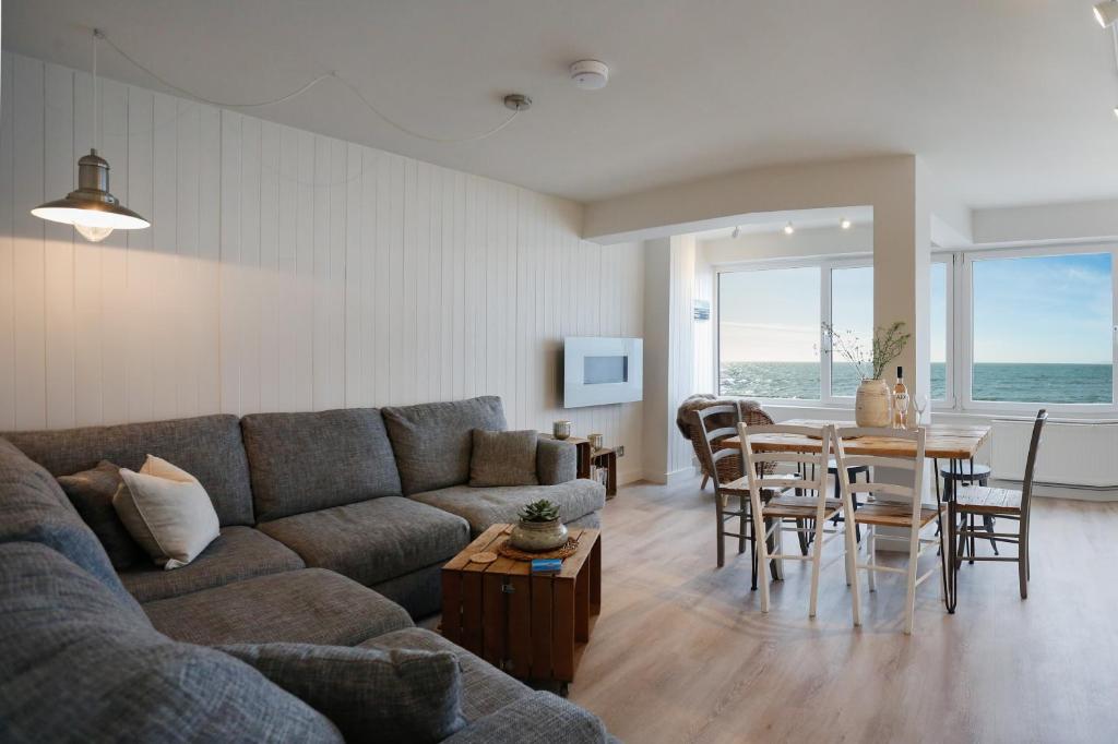 a living room with a couch and a table and chairs at Sea Spray - Bracklesham Bay in Chichester