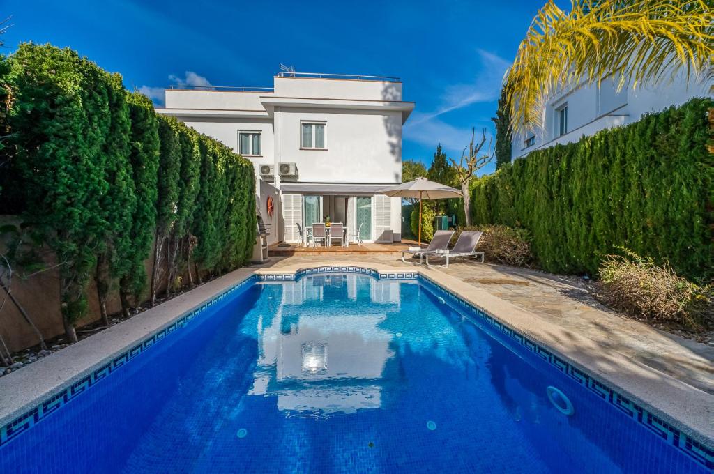 a swimming pool in front of a house at Traumhafte Villa Maricel für 8 Gäste am Meer in Alcudia