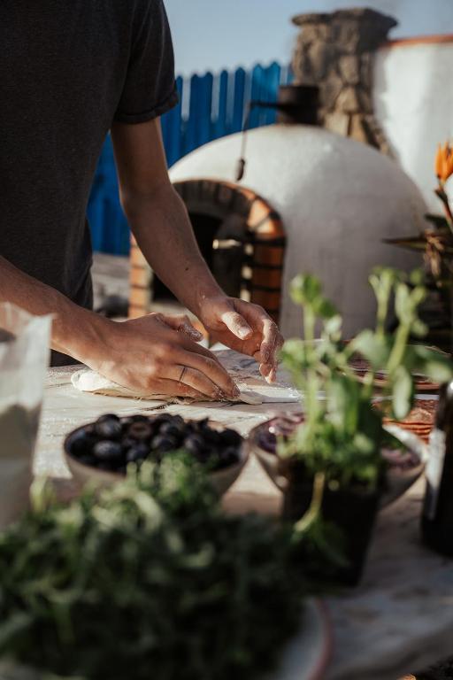 a man is preparing food in front of an oven at João Jungle in Açafora