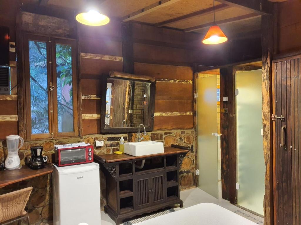 a kitchen with a counter and a sink in a room at Chalés Catavento in Maresias