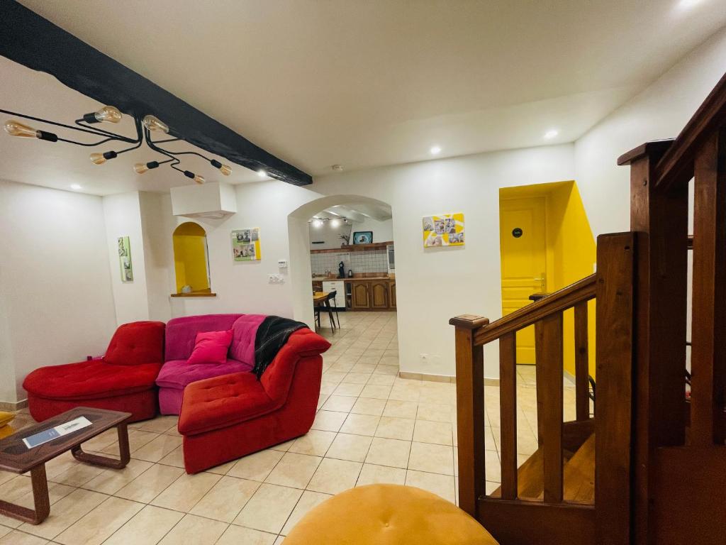 ein Wohnzimmer mit einem roten Sofa und einem Tisch in der Unterkunft Au 81 - maison de ville à louer in Moirans