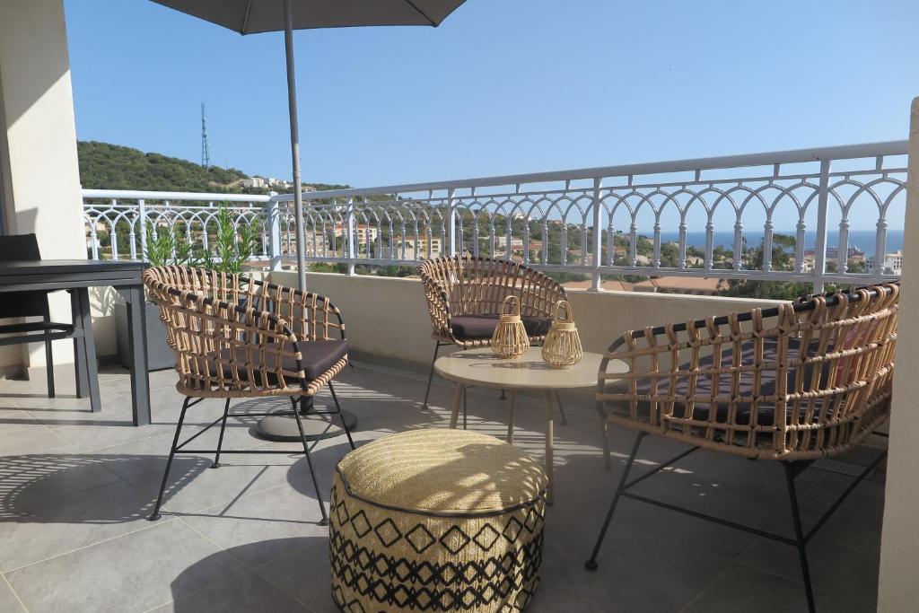 un patio avec des chaises, une table et un parasol dans l'établissement Pietra Bella, à LʼÎle-Rousse