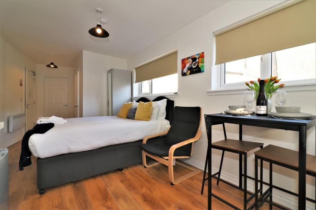 Signature - No 3 Bonnet Apartments في لانارك: غرفة نوم بسرير وطاولة ومكتب