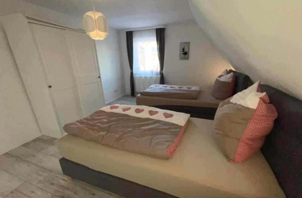 1 dormitorio pequeño con 2 camas y sofá en Ferienwohnung mit WiFi und 2 Schlafzimmern en Ipsheim