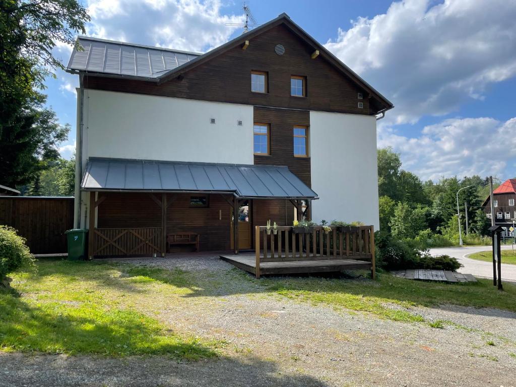 un grande fienile bianco con portico e panchina di Na sjezdovce a Sedloňov