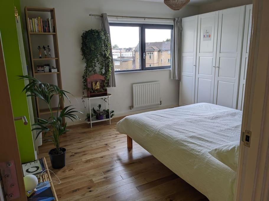 1 dormitorio con cama y ventana en Cheersome en Londres