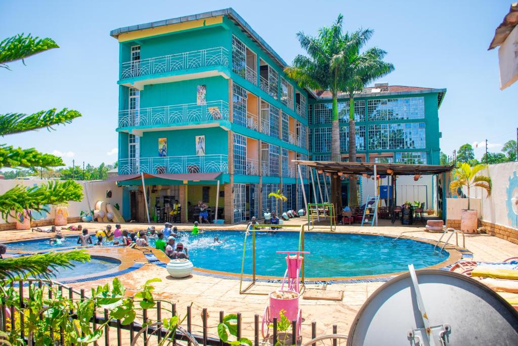 a hotel with a swimming pool in front of a building at The New Quill Hotel in Busia