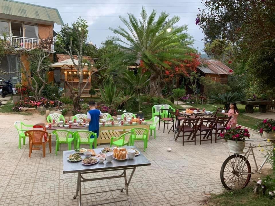 a group of tables and chairs with food on them at Chú Ba Farmstay - cách Đà Lạt 40km in Ấp Phú Thuận
