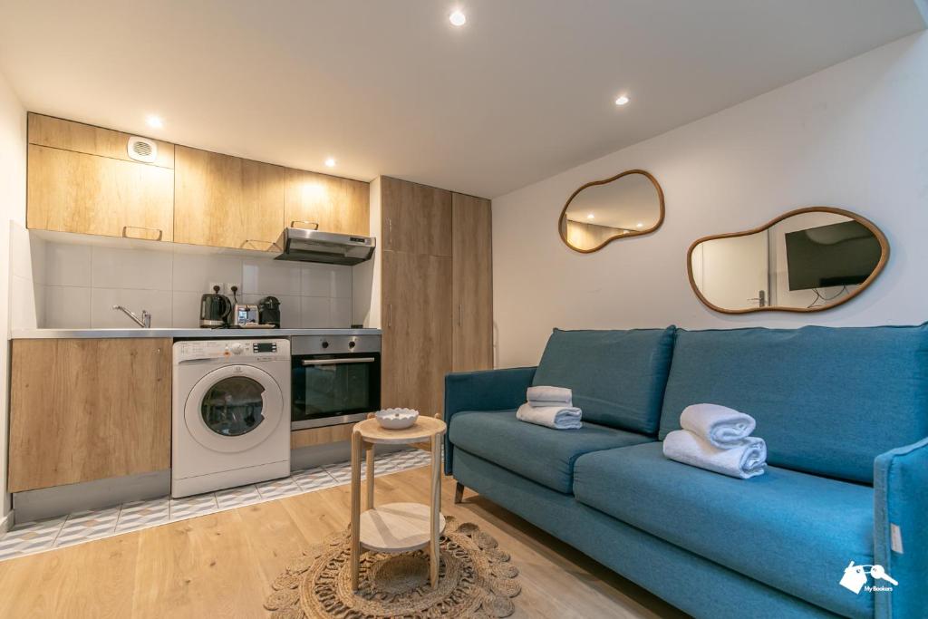 un salon avec un canapé bleu et une cuisine dans l'établissement MBA - Splendide Appart - Gambey 2 - Proche République, à Paris